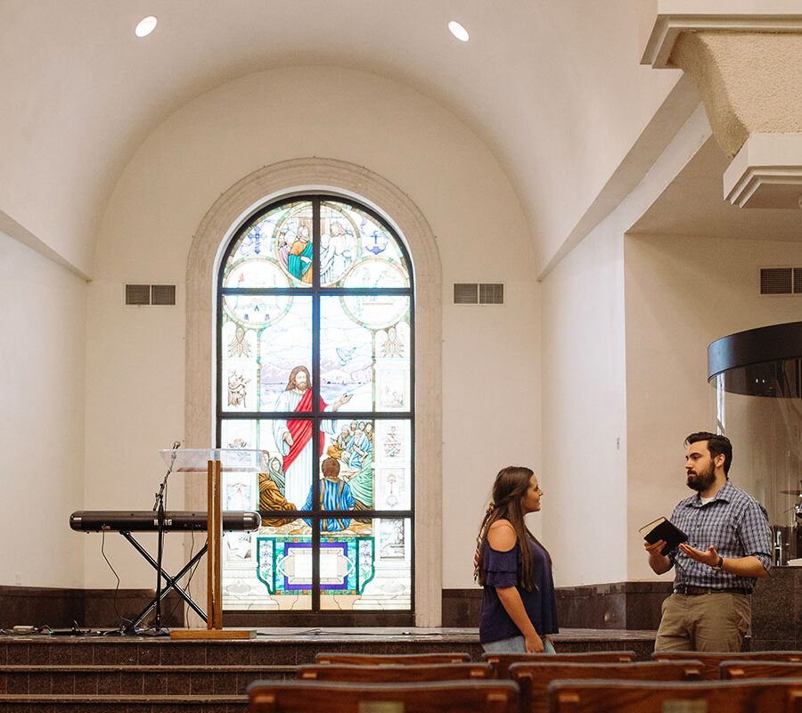 ministry student in the chapel providing counsel to another student